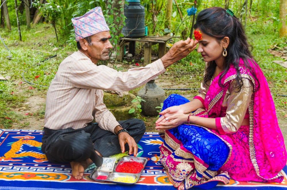 a-daughter-puts-tika-from-her-father-on-dashain.png